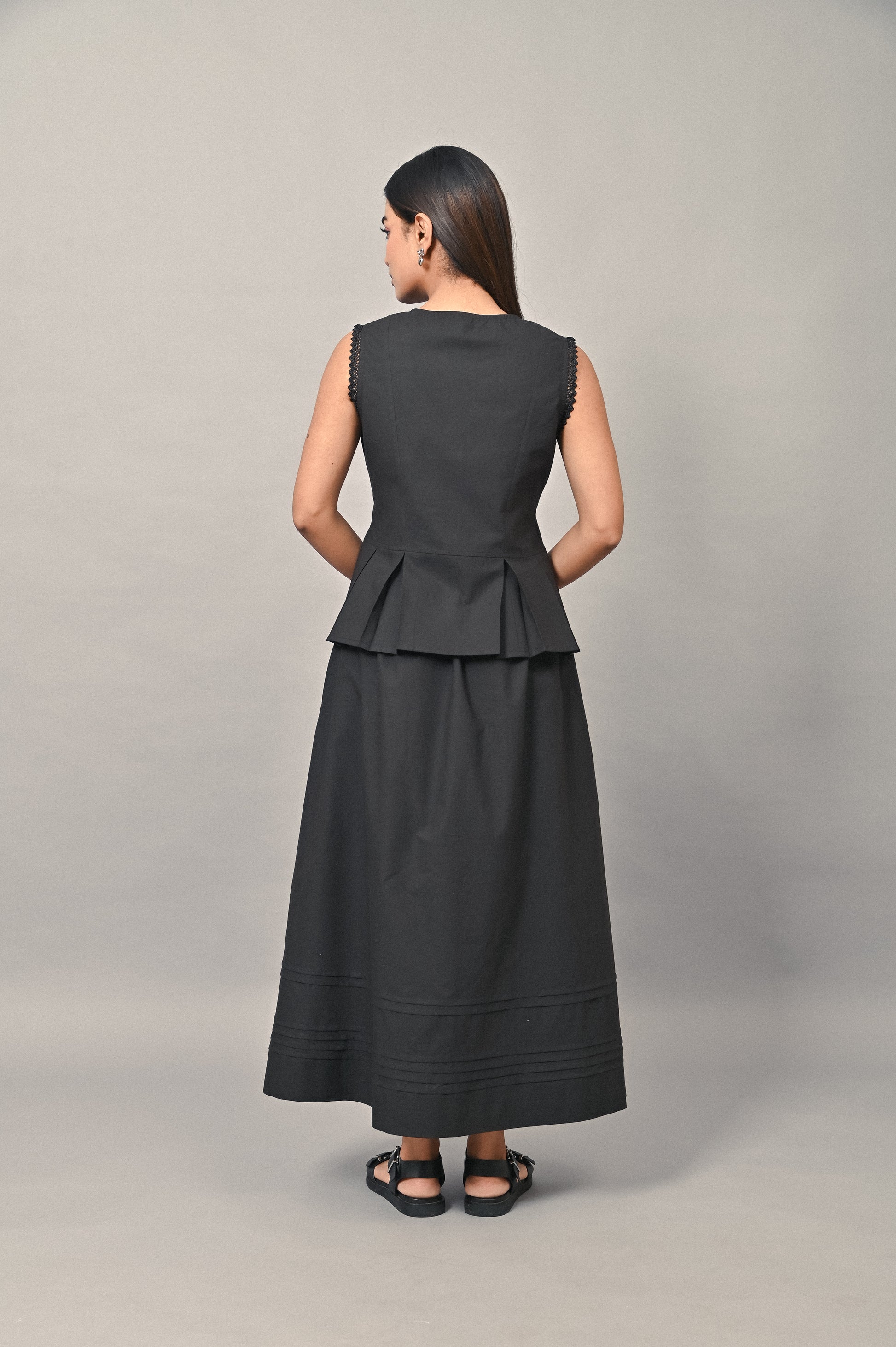 Sleeveless black cotton peplum set back view